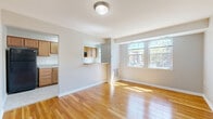 Located at 1720 27th St SE in Washington, DC, this two-bedroom, one-bathroom residence offers a practical and well-organized single-floor layout. The living room serves as the heart of the space, featuring warm hardwood flooring that reflects natural light streaming in through a large set of street-facing windows. A pass-through counter seamlessly connects the living area to the kitchen, enhancing the open feel between the two spaces.

The kitchen is equipped with warm wood cabinetry extending to the upper walls, light countertops, a built-in sink, and black appliances including a refrigerator and range. Tile flooring completes the functional cooking space. A hallway connects the main living areas to the two bedrooms, each finished with plush wall-to-wall carpeting and neutral tones. The primary bedroom offers a generous footprint with closet access and windows overlooking the surrounding neighborhood. The secondary bedroom features its own closet and hardwood flooring, providing flexibility in use.

The bathroom is clean and straightforward, outfitted with a full soaking tub, a pedestal sink, a medicine cabinet, and a window for natural ventilation. Throughout the residence, neutral wall colors and consistent finishes create a cohesive and inviting atmosphere.