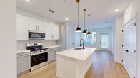 Located at 3911 Ambrosia St in Castle Rock, CO, this thoughtfully designed 2-bedroom, 2-bathroom single-floor residence offers a bright, modern living experience. Light wood-tone flooring flows throughout, complementing a clean, contemporary aesthetic with crisp white walls and black hardware accents.

The open-concept kitchen is a standout feature, showcasing white and light gray shaker cabinetry, a geometric hexagonal tile backsplash, quartz countertops, and a full suite of stainless steel appliances. A large center island with an undermount sink and brass pendant lighting serves as both a functional workspace and a social hub that opens seamlessly to the living area, which benefits from large windows and a patio door that fills the space with natural light.

Both bedrooms are well-proportioned and airy, each featuring ceiling fans, large windows with exterior views, and warm wood-tone flooring. The primary bedroom connects to a spa-inspired en-suite bathroom with large-format gray tile accent walls, an LED-backlit vanity mirror, and direct access to a generous walk-in closet equipped with built-in shelving and dual hanging rods. A dedicated laundry area and three closets throughout add practical storage. The patio provides a private outdoor retreat to complete this well-appointed home.