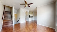 Located at 250 Treeline Park in San Antonio, TX, this three-story, 2-bedroom, 3-bathroom home offers a thoughtfully organized layout spread across three distinct levels. The ground floor houses an attached garage with an automatic opener, concrete flooring, and direct interior access via a staircase — providing both parking and additional storage potential.

The main living level serves as the heart of the home, featuring an open-concept layout where the living and dining areas flow seamlessly together. Rich hardwood-style flooring runs throughout, complemented by a ceiling fan and clean, neutral walls that invite natural light. The kitchen is well-appointed with white cabinetry, dark countertops, a mosaic tile backsplash, stainless steel appliances, and pendant lighting — combining style with function. A half bathroom with a pedestal sink and oval mirror is also conveniently located on this floor.

The upper level is dedicated to the two bedrooms, each carpeted and fitted with ceiling fans. The spacious primary bedroom includes a walk-in closet and an ensuite bathroom. The second bedroom is bright with a large window offering outdoor views. A laundry area, additional closet space, and hallways complete the upper floor. A balcony adds an inviting outdoor retreat. Throughout all three floors, wood-tread staircases with handrails provide elegant vertical connectivity.