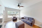 Located at 1321 Lovvorn Rd in Carrollton, GA, this well-appointed single-story home offers four bedrooms and four bathrooms, thoughtfully designed for comfortable living. The welcoming entrance leads into a bright living room featuring hardwood-style flooring, a ceiling fan, and large windows that frame lush greenery, filling the space with natural light and outdoor views. The kitchen is outfitted with dark cabinetry, granite-style countertops, black appliances including a range, microwave, and refrigerator, and a stylish tile backsplash — all connected by a clean, open hallway. Each of the four bedrooms is carpeted, generously sized, and includes its own dedicated closet and en-suite bathroom, offering privacy and convenience. The bathrooms feature dark wood vanities with light countertops, hardwood-style flooring, and tub-shower combinations. Additional rooms include a dedicated laundry area and a utility room. Throughout the home, neutral tones, clean white trim, and consistent finishes create a cohesive and modern aesthetic. The layout is efficient and functional, making excellent use of the available footprint to accommodate multiple occupants with ease.