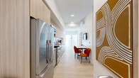 Located at 360 N Hayworth Ave in the heart of Los Angeles, this modern 4-bedroom, 3-bathroom unit delivers a clean, contemporary aesthetic throughout its well-designed single-floor layout. Light hardwood flooring runs seamlessly through the main living areas, complementing the bright white walls and recessed lighting that create an airy, open feel.

The galley-style kitchen is a standout feature, outfitted with sage green and light wood cabinetry, a gas range, stainless steel refrigerator, and sleek quartz countertops. It flows directly into a dining area with a marble-topped table, making the space both functional and visually cohesive.

The four bedrooms are comfortably proportioned, each featuring light wood floors, large windows that invite natural light, and closet storage. One bedroom offers direct access to a private balcony through sliding glass doors. The primary bedroom provides a quiet retreat with generous dimensions.

All three bathrooms maintain a consistent modern design language, featuring floating wood-toned vanities, black-framed mirrors, and textured wave-tile walls. Bathrooms include both walk-in glass-enclosed showers and curtain-style shower options. Mini-split HVAC units provide individualized climate control throughout. The overall ambiance is minimal, bright, and well-appointed — ideal for comfortable urban living in Los Angeles.