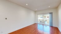Located in the heart of West Hollywood, CA, this efficiently designed single-floor unit offers a well-organized layout comprising a living room, kitchen, bathroom, hallway, and closet. The living room is a bright, open space highlighted by rich, polished hardwood floors that reflect natural light, crisp white walls, and recessed lighting. A sliding glass door opens directly to an outdoor patio area, enhancing the sense of space and allowing for seamless indoor-outdoor living. The kitchen is thoughtfully updated with white shaker-style cabinetry, sleek quartz countertops, a mosaic tile backsplash, and stainless steel appliances including a gas range, dishwasher, and full-size refrigerator. Light-toned tile flooring and a window bring brightness into the galley-style workspace. The bathroom features a clean, contemporary design with large-format floor tiles, a tiled shower-tub combination, a window for natural ventilation, and a white vanity with quartz countertop. Recessed lighting throughout the main living areas and clean white walls contribute to a bright, minimalist aesthetic, while the consistent use of quality finishes gives the space a polished, cohesive feel.