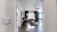 Located at 14811 West Road in Houston, TX, this well-appointed 2-bedroom, 3-bathroom single-story home offers a thoughtfully designed layout across a comfortable footprint. Dark hardwood-style flooring flows throughout the main living areas, creating a cohesive and sophisticated aesthetic.

The open living room is a standout space, featuring large windows dressed in floor-to-ceiling navy curtains that allow generous natural light, a ceiling fan, and crown molding. It connects seamlessly to a dining area and kitchen with a breakfast bar and stainless steel appliances. A striking teal accent wall with arched architectural details defines the transition space between rooms, adding character and visual depth.

The spacious primary bedroom includes plush carpeting, natural light from exterior windows, and access to a walk-in closet outfitted with multi-tier wire shelving and hanging rods. The primary bathroom features granite-topped white cabinetry and a tiled tub-shower combination. The second bedroom also features carpet, a bold botanical wallpaper accent wall, and a ceiling fan.

Three bathrooms provide ample convenience, each finished with granite countertops and hardwood-style flooring. The dedicated laundry area accommodates a full-size side-by-side washer and dryer. Multiple hallways and two closets further enhance the home's functional storage and circulation throughout.