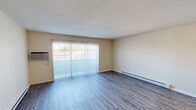 Located at 11721 E Nora Ave in Spokane Valley, WA, this one-bedroom, one-bathroom unit offers a practical and comfortable single-floor layout. The combined living and dining area is the heart of the home, featuring durable wood-style flooring, a textured ceiling, and a large sliding glass door dressed with vertical blinds that fills the space with natural light and provides direct access to a private patio. A wall-mounted A/C unit and baseboard heating ensure year-round comfort. The patio offers an open view of the surrounding community and distant mountain scenery.

The galley-style kitchen is well-equipped with warm oak cabinetry, ample counter space, a double-basin sink, a full-size refrigerator, an electric range with overhead ventilation, and a dishwasher. Hardwood-style flooring runs throughout, connecting the kitchen seamlessly to the rest of the unit.

The bedroom is a calm, well-proportioned retreat with a dedicated window that invites natural light and a baseboard heater for warmth. A closet provides convenient storage. The bathroom features a full tub-shower combination, a single-sink vanity with wood cabinetry, and a clean, neutral finish throughout. The unit also includes in-unit laundry access, adding to its everyday functionality.