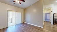 Located at 4292 N Seasons View Dr in Lehi, Utah, this well-appointed 2-bedroom, 2-bathroom single-floor home offers a functional and comfortable layout. The living room features warm wood-look flooring, vaulted ceilings, a ceiling fan, and a sliding glass door fitted with vertical blinds that invite natural light and provide access to the outdoors. The kitchen is a standout space, showcasing sleek white cabinetry, bold black countertops, stainless steel appliances, a peninsula with bar seating, and pendant lighting overhead — ideal for both cooking and casual dining. The primary bedroom is generously sized with vaulted ceilings, wood-look flooring, a ceiling fan, and its own sliding glass door for added light and outdoor access. Both walk-in closets are outfitted with multi-tier shelving and hanging rods, offering ample storage. The secondary bedroom features plush carpeting, a large window with natural light, and a clean, neutral palette. Both bathrooms are well-equipped, with one featuring tile flooring, white cabinetry with dark countertops, and a shower-tub combination. Throughout the home, neutral tones and consistent finishes create a cohesive, move-in-ready atmosphere.