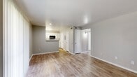 This thoughtfully designed 2-bedroom, 2-bathroom residence offers a practical and comfortable single-floor layout with a clean, neutral aesthetic throughout. The open living area greets you with warm wood-style luxury vinyl flooring, soft gray walls, and a sliding glass door fitted with vertical blinds that invites natural light and provides outdoor access. The galley-style kitchen is outfitted with crisp white cabinetry, speckled stone countertops, a stainless steel sink, and black appliances including a range, dishwasher, refrigerator, and microwave. A pass-through counter connects the kitchen to the living area, enhancing the open feel of the space. Both bedrooms feature plush carpeting and ceiling fans with integrated lighting. The spacious primary bedroom includes two closets, offering generous storage. The second bedroom is well-proportioned with a window that brings in natural light. Each bathroom is finished with white cabinetry, stone-topped vanities, and a tub-shower combination. Two dedicated closets provide additional storage throughout the unit. The consistent use of light tones, wood-style flooring, and clean finishes creates a cohesive, move-in-ready environment.