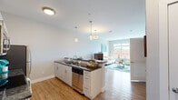Located at 1178 Silas Deane Hwy in Wethersfield, CT, this well-appointed one-bedroom, one-bathroom residence offers a thoughtfully designed open-concept layout across a single floor. The combined kitchen and living area serves as the heart of the home, featuring warm hardwood-style flooring throughout. The kitchen is equipped with stainless steel appliances — including a range, microwave, dishwasher, and refrigerator — complemented by crisp white cabinetry, a subway tile backsplash, and dark granite countertops that extend to a peninsula with bar seating. Pendant lighting adds a refined touch overhead. The living area is bright and airy, anchored by a large picture window that fills the space with natural light and offers views of the surrounding neighborhood. The bedroom is a comfortable retreat with plush carpet flooring, a window with outdoor views, and a dedicated workspace area. A spacious walk-in closet with built-in wire shelving and hanging rods provides generous storage. The bathroom features a granite-topped vanity with light wood cabinetry, a framed mirror, and tile flooring, maintaining the consistent modern aesthetic found throughout the residence. Neutral tones and clean lines give the entire unit a fresh, contemporary feel.