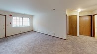 Located at 2677 S 108th St in West Allis, Wisconsin, this single-floor unit offers a straightforward, functional layout designed for comfortable everyday living. The space is organized to provide clear transitions between the living, sleeping, and utility areas.

The galley-style kitchen runs along two parallel walls, featuring oak cabinetry, dark laminate countertops, tile flooring, and white appliances including a refrigerator and electric range. A double-basin sink and dishwasher add to the kitchen's practicality.

The living area is generously proportioned, finished with neutral wall-to-wall carpeting and white walls that create a bright, open feel. A window allows natural light to filter in, and interior doors with warm oak finishes provide visual continuity throughout. An adjacent room—suitable as a bedroom—offers its own closet with a full-width rod and shelf, along with a sliding glass door fitted with vertical blinds that opens to an outdoor view, bringing in additional natural light.

A second carpeted room also serves well as a bedroom or flexible living space, featuring a window and a nearby interior door.

The full bathroom includes a tub-shower combination, a toilet, and an oak vanity with a single sink and mirror, finished with tile flooring that complements the overall aesthetic of the unit.