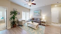 Located at 1005 Sonoran Cir in Summerville, SC, this well-designed 2-bedroom, 2-bathroom single-floor home offers a comfortable and cohesive living experience with a coastal aesthetic throughout. The open-concept layout connects the living room, dining area, and kitchen, creating a seamless flow ideal for everyday living. The living room is bright and inviting, featuring light hardwood-style flooring, a ceiling fan, and a glass-panel door that allows natural light to pour in. The kitchen is equipped with white cabinetry, stainless steel appliances, a subway tile backsplash, granite countertops, and a breakfast bar with seating — perfect for casual dining. A separate dining nook provides an intimate space for meals. The primary bedroom features plush carpeting, a ceiling fan, natural light from a window with blinds, a walk-in closet with built-in shelving, and an additional closet for ample storage. The second bedroom is similarly well-appointed with carpeting, a ceiling fan, and a window. Both bathrooms are clean and functional, with one featuring a full tub-shower combination. A dedicated laundry room with overhead shelving completes this thoughtfully laid-out home.