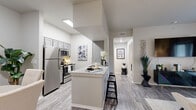 This single-floor unit offers a thoughtfully laid-out living space with a neutral, modern aesthetic throughout. The open-concept kitchen and living area serves as the heart of the unit, featuring wood-look plank flooring, a kitchen island with granite-style countertops and bar seating, and gray shaker-style cabinetry. Stainless steel appliances, including a refrigerator, range, and microwave, provide a complete and functional cooking space. The living area is bright and airy, benefiting from large windows that invite natural light and are dressed with floor-to-ceiling drape panels.

A hallway connects the main living space to the private bedroom, which features plush carpet flooring, a generously sized window, and a closet. The room comfortably accommodates a full-size bed with space for additional furnishings. Two bathrooms serve the unit, each finished consistently with granite-style countertops, gray cabinetry with brushed nickel hardware, and wood-look tile flooring. One bathroom includes a full soaking tub with shower. The overall palette of soft whites and grays creates a cohesive, calm ambiance throughout the unit.