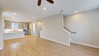Located at 5026 Zion Rd in Garland, TX, this thoughtfully designed three-story home offers a functional and modern layout spread across multiple levels. The ground floor houses an attached garage with interior access, seamlessly connecting to the main living areas above. The first floor serves as the heart of the home, featuring an open-concept kitchen and living room bathed in recessed lighting and outfitted with light hardwood-style flooring. The kitchen is well-appointed with gray shaker-style cabinetry, a white subway tile backsplash, stainless steel appliances including a French door refrigerator, and a peninsula island with a clean white countertop. A pantry and convenient hallway round out this level, while a staircase with a warm wood handrail connects all three floors. The second floor hosts both bedrooms, three closets, a laundry area, and a dedicated office. The generously sized primary bedroom includes its own well-appointed bathroom featuring a dual-sink vanity with white quartz countertops, modern chrome fixtures, and ample cabinetry. Each bedroom benefits from ceiling fans, plush carpeting, and natural light from windows with views of the surrounding neighborhood. Neutral tones and clean finishes throughout give the home a fresh, move-in-ready feel.