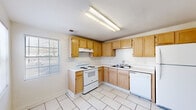 Located at 540 Oglethorpe Ave in Athens, GA, this single-story, 3-bedroom, 1-bathroom home offers a practical and straightforward layout across its single floor. The entry welcomes you through a paneled white door into a bright, tile-floored foyer with a window that brings in natural light.

The kitchen is efficiently designed in an L-shaped configuration, featuring warm honey-toned wood cabinetry — both upper and lower — with white countertops, a white electric coil range, a double-basin sink, and a dishwasher. Light ceramic tile flooring and a mounted fluorescent light fixture complete the functional space.

The bedrooms are carpeted and neutrally painted, providing a comfortable and quiet atmosphere. The primary bedroom benefits from dual windows and a ceiling fan with light fixture, allowing for ample natural light and air circulation. Additional bedrooms are similarly appointed with ceiling fans and windows. One room features tile flooring and a window, offering flexible use as a bedroom or living area.

The full bathroom is clean and simple, with tile flooring, a tub/shower combination, and a flush-mount ceiling light. A dedicated utility room adds practical storage and functional convenience. Throughout the home, white walls and light-toned finishes create a bright, cohesive aesthetic.