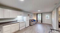 Located at 4285 Kent Rd in Stow, Ohio, this compact and well-appointed one-bedroom, one-bathroom unit offers a thoughtfully designed single-floor layout. Light gray walls, wood-look laminate flooring, and recessed lighting run throughout, creating a clean and cohesive aesthetic.

The open-concept kitchen and living area forms the heart of the unit. The kitchen features white shaker-style cabinetry, dark laminate countertops, a stainless steel single-basin sink, and white appliances including an electric range and full-size refrigerator. A pass-through window connects the kitchen to the dining area, which accommodates a small table and chairs. Natural light filters in through multiple windows, enhancing the overall brightness of the shared living space.

The living room offers a welcoming atmosphere with large windows dressed in dark curtain panels, a baseboard heater, and direct access to the exterior through a windowed entry door. The bedroom is a comfortable size with its own dedicated closet storage. Two closets — including a walk-in with wire shelving — provide practical organization options.

The bathroom is equipped with a walk-in shower featuring grab bars for accessibility, a toilet, and a vanity. Clean, neutral finishes maintain consistency with the rest of the unit. Overall, the space is efficiently arranged and move-in ready.