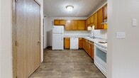 Located at 1405 Marion Rd SE in Rochester, Minnesota, this single-floor unit offers a practical and well-organized layout suited for comfortable everyday living. The kitchen is equipped with warm honey-toned wood cabinetry, laminate countertops, and a full suite of white appliances including a refrigerator, dishwasher, and range. Wood-look vinyl flooring runs throughout the kitchen, providing durability and easy maintenance. The living area is carpeted and features a sliding glass door that opens to a private balcony with views of surrounding greenery, allowing natural light to fill the space. A wall-mounted air conditioning unit and baseboard heating ensure year-round climate control. The bedroom offers generous closet storage with two sets of sliding double-door closets and is finished with plush carpet and baseboard heating. An additional carpeted room with a large window brings in further natural light. The full bathroom includes a single-sink vanity with warm wood cabinetry, a toilet, and a tub-shower combination, all finished with the same wood-look flooring found in the kitchen. Neutral wall tones and consistent wood-trim accents throughout the unit create a cohesive and understated aesthetic.