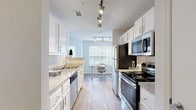 Located at 2222 East West Connector in Austell, Georgia, this single-floor residence offers a thoughtfully designed layout that balances comfort and functionality. Wood-look flooring flows through the main living areas, providing a cohesive and modern aesthetic throughout.

The galley-style kitchen is a standout feature, outfitted with white cabinetry, granite-look countertops, stainless steel appliances including a range, microwave, dishwasher, and refrigerator, and track lighting overhead. Natural light filters in through a window at the far end, creating a bright and inviting workspace. The kitchen opens toward a dedicated dining area, which comfortably accommodates a full-size dining table and connects seamlessly to the living room — an open, relaxed space with wood-look flooring and neutral walls ideal for everyday living.

Both bedrooms are carpeted and well-proportioned, each offering natural light from large windows. The secondary bedroom features a pleasant outdoor view through its window. Two full bathrooms serve the residence, each finished with wood-look flooring, white vanity cabinetry, and a shower-tub combination. The overall design is clean, bright, and consistent, making this a practical and comfortable home in the Austell community.