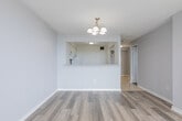 Located on Rathburn Road East in Mississauga, Ontario, this 1-bedroom, 1-bathroom unit offers a practical and comfortable layout across a single floor. Upon entry, a hallway with a large sliding-door closet provides generous storage and leads into the main living areas. The combined kitchen and living room forms the heart of the unit. The kitchen is outfitted with white cabinetry, ample upper and lower storage, a double sink with countertop workspace, and full-sized white appliances including an electric range and refrigerator, all set on clean light tile flooring. The living room is bright and airy, featuring light hardwood-style flooring, soft neutral walls, a tasteful chandelier, and a large window that fills the space with natural light. A sliding glass door opens onto a private balcony, extending the living space outdoors. The bedroom is a comfortable size, finished with rich wood-tone laminate flooring, neutral grey walls, and a window offering pleasant outdoor views. The bathroom is clean and functional, featuring a full soaker tub with a tiled surround and handheld showerhead, a vanity with sink, and tile flooring throughout. Textured ceilings are consistent throughout the unit, adding a classic character to this well-maintained Mississauga residence.