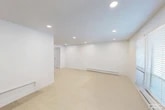 Located at 3 Avon Pkwy in Liverpool, NY, this efficiently designed single-floor unit offers a well-organized layout comprising a living room, one bedroom, a kitchenette, one full bathroom, and four closets. The open living and reception area is bright and airy, featuring recessed lighting, light-toned flooring, clean white walls, and a welcoming atmosphere with ample room for both seating and workspace arrangements. The space is versatile, with the main area accommodating desk workstations and a round meeting table, making it suitable for professional use. The bedroom is a well-proportioned private room outfitted with a ceiling fan, a window with blinds allowing natural light, and enough space for a full office or personal workstation setup. The kitchenette is sleek and functional, featuring white cabinetry with modern black hardware, a stainless steel sink, white countertops, and overhead appliance space. The bathroom is clean and straightforward, with white cabinetry for storage, a shower with curtain, and a full-length mirror with gold-tone framing. The four closets provide exceptional storage throughout the unit. Overall, the space presents a clean, minimal, and practical environment well-suited for professional or personal use.