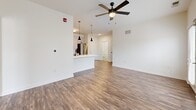 Located at 601 NE 70th St in Gladstone, Missouri, this well-appointed 2-bedroom, 3-bathroom single-floor residence offers a thoughtfully designed layout with modern finishes throughout. The open-concept living and kitchen area serves as the heart of the home, featuring rich wood-look plank flooring, a ceiling fan with light, and direct access to an outdoor space through glass-paned doors flanked by windows that invite abundant natural light. The kitchen is a standout, showcasing white shaker-style cabinetry with black hardware, bright white countertops, a central island with an undermount sink and pendant lighting, and a full suite of stainless steel appliances including a refrigerator, range, microwave, and dishwasher. The spacious primary bedroom is carpeted for comfort, includes a ceiling fan, and connects to a dedicated closet and a private bathroom featuring a tiled walk-in shower with glass doors and tile flooring. The second bedroom is similarly carpeted, equipped with a ceiling fan, and benefits from a large window with exterior views. Three closets across the unit, including a generously sized walk-in with wire shelving, provide excellent storage. A dedicated laundry room and utility room round out the functional layout of this clean, move-in-ready home.