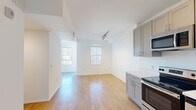 Located on the iconic Sunset Boulevard in the heart of Hollywood, this one-bedroom, one-bathroom unit offers a thoughtfully designed layout across a single floor. The open-plan living and kitchen area is bathed in natural light from multiple windows fitted with vertical blinds, creating a clean and airy atmosphere. Light wood-style flooring flows seamlessly throughout the space, complementing the crisp white walls and modern finishes.

The kitchen is well-appointed with taupe shaker-style cabinetry extending to the ceiling, offering generous storage. A full suite of stainless steel appliances includes a range, microwave, dishwasher, and refrigerator, all paired with bright white countertops and a double-basin sink. Track lighting accents the living area, adding a contemporary touch.

The spacious primary bedroom receives abundant natural light through large windows, creating a bright and welcoming retreat. The clean white walls and wood-style flooring carry through cohesively from the main living space.

The bathroom features a full bathtub with shower, wood-look tile flooring, and a clean, minimalist design with white walls and modern fixtures. This unit presents a streamlined, modern living experience in one of Los Angeles' most vibrant and sought-after neighborhoods.