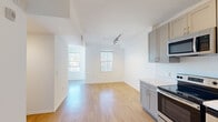 Located on the iconic Sunset Boulevard in the heart of Hollywood, this one-bedroom, one-bathroom unit offers a thoughtfully designed layout across a single floor. The open-plan living and kitchen area is bathed in natural light from multiple windows fitted with vertical blinds, creating a clean and airy atmosphere. Light wood-style flooring flows seamlessly throughout the space, complementing the crisp white walls and modern finishes.

The kitchen is well-appointed with taupe shaker-style cabinetry extending to the ceiling, offering generous storage. A full suite of stainless steel appliances includes a range, microwave, dishwasher, and refrigerator, all paired with bright white countertops and a double-basin sink. Track lighting accents the living area, adding a contemporary touch.

The spacious primary bedroom receives abundant natural light through large windows, creating a bright and welcoming retreat. The clean white walls and wood-style flooring carry through cohesively from the main living space.

The bathroom features a full bathtub with shower, wood-look tile flooring, and a clean, minimalist design with white walls and modern fixtures. This unit presents a streamlined, modern living experience in one of Los Angeles' most vibrant and sought-after neighborhoods.