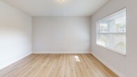 Located in Tampa, FL, this thoughtfully updated 2-bedroom, 1-bathroom single-story home offers a clean, modern aesthetic throughout. Light wood-style flooring runs continuously through the living areas and bedrooms, creating a bright and cohesive feel. The open entryway connects to a well-defined hallway lined with six-panel white doors accented by matte black hardware, lending a contemporary touch to the interior.

The kitchen is efficiently designed with white shaker-style cabinetry, light tile flooring, and a full suite of stainless steel appliances including a range, microwave, and refrigerator — providing everything needed for daily use. The combined kitchen and living area maximizes the available footprint.

Both bedrooms are comfortably sized with large windows that invite natural light and offer views of surrounding greenery. The primary bedroom features a sliding double-door closet for ample storage. Each bedroom benefits from HVAC vents and neutral wall tones that keep the spaces feeling airy and versatile.

The bathroom is finished with light wood-look tile flooring, a white vanity with cabinet storage, and a tiled tub-shower combination — all accented with matte black fixtures for a cohesive, modern look. This home presents a well-maintained, move-in ready option in a convenient Tampa location.
