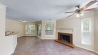 Located at 601 Jones Ferry Rd in Carrboro, NC, this well-appointed 2-bedroom, 3-bathroom single-floor residence offers a functional and comfortable layout throughout. Rich, dark hardwood-style flooring runs continuously through the home, lending warmth and cohesion to every room.

The living room serves as the centerpiece of the home, highlighted by a classic brick fireplace with a white mantel, crown molding, a textured ceiling, and a ceiling fan. A charming bay window floods the space with natural light and offers views of the surrounding greenery. The adjacent entryway provides a welcoming transition into the main living area.

The kitchen features an open-concept design with a peninsula counter finished in granite-style laminate, dark espresso cabinetry, and stainless steel appliances including a refrigerator, dishwasher, and range with microwave. A window above the dining area brings in additional natural light.

Both bedrooms are comfortably sized with neutral warm-toned walls and hardwood-style flooring. The primary bedroom is notably spacious and includes access to a closet. The hallway connects the rooms efficiently and features additional bathroom access with granite countertops and dark cabinetry.

Three bathrooms serve the home, including one with a full tub and white subway tile surround. The overall ambiance is clean, bright, and move-in ready.