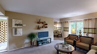 Located at 7503 Brushfield Ct in Rosedale, MD, this single-floor, one-bedroom, one-bathroom residence offers a thoughtfully designed layout across a compact yet functional footprint. The open-concept living and dining area is warm and inviting, with neutral-toned walls, plush carpeting, and large windows dressed with layered curtains that allow natural light to fill the space. The living room features wall-mounted shelving and flows seamlessly into the dining area, which is highlighted by a pendant light fixture overhead. The kitchen is well-equipped with rich wood cabinetry, granite countertops, tile flooring, and a convenient stacked in-unit washer and dryer. The generously sized bedroom offers ample room for a full furniture arrangement and includes a built-in closet with shelving and hanging storage. The bathroom is finished with granite countertops, wood cabinetry, and a tub-shower combination. A hallway connects the rooms efficiently, contributing to the overall cohesive flow of the residence. Throughout the home, consistent warm tones and quality finishes create a comfortable and functional living environment.