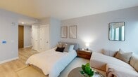 Located at 325 Huguenot St in New Rochelle, NY, this thoughtfully designed one-bedroom, one-bathroom residence offers a modern living experience across a single floor. The open-concept layout maximizes every inch of the space, seamlessly connecting the living, dining, and kitchen areas. Floor-to-ceiling windows flood the main living area with natural light and provide expansive urban views, creating an airy, bright atmosphere. Light-toned hardwood flooring flows throughout, complementing the neutral color palette of soft grays and whites.

The kitchen features contemporary flat-panel cabinetry in a warm wood finish, a stainless steel refrigerator, and clean white countertops — all designed for both functionality and style. A smart thermostat is conveniently positioned in the main living area. The generously sized primary bedroom offers a calm, restful retreat with soft tones, ample space, and access to closets. The bathroom is finished with large-format tile flooring, a light wood vanity with under-cabinet storage, a framed mirror with overhead lighting, and a separate shower enclosure. Every element of this residence reflects a clean, modern aesthetic suited for contemporary urban living.
