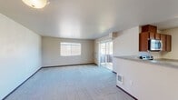 Located at 15001 North Wandermere Rd in Spokane, WA, this single-floor, 3-bedroom, 2-bathroom home offers a comfortable and functional layout. The open-concept living, dining, and kitchen area forms the heart of the home, bathed in natural light from large windows and a sliding glass door that leads to a private balcony with views of the surrounding neighborhood and mature trees. The kitchen is well-appointed with warm, rich wood cabinetry, light countertops, a double-basin sink, and stainless steel appliances including a dishwasher and microwave. Soft carpet flows throughout the living areas and all three bedrooms, complemented by clean, neutral wall tones that create a bright and welcoming ambiance. Each bedroom is generously sized, featuring natural light and ample closet space, with the primary bedroom offering a comfortable retreat. Five closets are distributed throughout the home, providing exceptional storage. The two bathrooms are finished with wood-toned vanities and light hardwood-style flooring, with one bathroom featuring a full tub-shower combination. A dedicated laundry area adds everyday convenience, rounding out this well-organized and practical Spokane residence.
