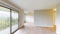 This thoughtfully designed 2-bedroom residence offers a comfortable and functional layout across a single floor. The open-concept kitchen and living area serves as the heart of the home, featuring a galley-style kitchen outfitted with crisp white cabinetry, brushed nickel hardware, laminate countertops, and black appliances including a range, refrigerator, and dishwasher. A ceiling fan overhead and a large window framing lush, wooded views bring natural light and airflow into the combined dining space. Light-tone luxury vinyl plank flooring runs throughout the main living areas, complementing the neutral wall palette.

The living room extends to a private balcony through a sliding glass door, offering elevated outdoor views of the surrounding greenery. Baseboard heating is present throughout the unit for consistent comfort.

Both bedrooms are carpeted and feature generous closet space — the primary bedroom includes a double bi-fold closet setup, while the second bedroom offers its own dedicated closet. Each bedroom is quiet and well-lit, with windows that bring in natural light. Textured ceilings add a classic touch throughout. The overall ambiance is clean, neutral, and move-in ready, making this a practical and inviting space.