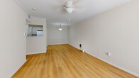 Located at 109 Charolais St in Lafayette, Louisiana, this single-floor, one-bedroom, one-bathroom home offers a efficient and well-organized layout. Light-toned wood-look flooring runs throughout the entire space, creating a cohesive and clean aesthetic. The living room is an open, airy area enhanced by crown molding, a ceiling fan, and a pass-through opening to the kitchen, allowing natural light to flow freely. A pendant light fixture adds a warm focal point between the two areas. The galley-style kitchen is thoughtfully designed with white cabinetry, ample counter space, a stainless steel sink, and full appliances including a refrigerator and dishwasher. A dedicated laundry area is conveniently integrated into the kitchen space. The bedroom is a comfortable, well-proportioned room featuring a ceiling fan, natural light from a window with blinds, and access to a closet. The bathroom is cleanly finished with gray cabinetry, a white vanity countertop, and a full tub-shower combination with white tile surround and brushed nickel fixtures. Throughout the home, neutral wall tones and white trim contribute to a bright, move-in-ready atmosphere.