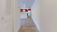 Located at 1202 Prairie Ln in Titusville, Florida, this single-story home offers three bedrooms, two bathrooms, and a practical, well-organized layout. The kitchen is a standout feature, equipped with rich cherry wood cabinetry, white appliances including a range, microwave, refrigerator, and dishwasher, and a peninsula that opens toward the living area. Track lighting illuminates the kitchen, while tile flooring adds a clean, durable surface underfoot. The living and bedroom areas are finished with neutral carpet, creating a warm and cohesive feel throughout. Each bedroom is bright and airy, benefiting from large windows that invite natural light and offer views of the surrounding greenery. Ceiling fans in the bedrooms provide added comfort. The two bathrooms are finished with tile flooring and warm wood-toned vanities; one bathroom includes a tub-shower combination with white tile surround, while the second features dual mirrors and a spacious countertop. A dedicated closet with built-in wire shelving provides convenient storage. The home's clean white walls and consistent finishes throughout give it a bright, neutral ambiance well-suited for a variety of living arrangements.