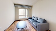 Located on the fourth floor at 309 Oak St SE in Minneapolis, this one-bedroom, one-bathroom unit offers a practical and well-designed layout across a single floor. The kitchen is a standout feature, outfitted with warm-toned wood cabinetry, granite-style countertops, stainless steel appliances including a refrigerator, range, microwave, and dishwasher, and a peninsula with bar seating illuminated by pendant lighting and track lights overhead. Hardwood flooring runs throughout the kitchen and living room, adding warmth to the space. The living room is compact yet functional, featuring a window that brings in natural light and views of the surrounding building exterior. The bedroom is carpeted and includes a window for additional light and ventilation, with exposed ductwork adding an industrial touch. A dedicated walk-in closet provides wire shelving overhead and built-in drawer storage below, offering organized storage capacity. The bathroom includes a wood-tone vanity with a stone-topped sink, tile flooring, open shelving, and a full-size soaking tub with shower. This unit combines modern fixtures with practical finishes throughout.