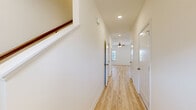 This two-story home in Bowling Green, Kentucky offers three bedrooms and two and a half bathrooms across a thoughtfully laid-out floor plan. Light hardwood-style flooring runs throughout, lending a clean, cohesive look to both levels. The main floor hosts the kitchen and living area, where warm honey-toned cabinetry, light countertops, a double-basin sink, and white appliances — including a refrigerator with ice maker, range, and built-in microwave — provide a fully functional cooking space. A staircase connects to the upper level, where a bright hallway lined with recessed lighting leads to all three bedrooms. Each bedroom features light hardwood floors, neutral walls, and windows that invite natural light; the primary bedroom offers dual windows and a ceiling fan for added comfort. The bathrooms are consistent in design, each featuring a tub-shower combination, warm wood vanity cabinetry, and light countertops with a single sink. A dedicated laundry room on the upper floor comes equipped with a full-size washer and dryer. Clean finishes, ceiling fans, and an abundance of natural light throughout make this a practical and comfortable two-story home.