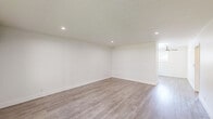 Located on Riverside Drive in the Valley Village neighborhood of Los Angeles, this 2-bedroom, 2-bathroom residence offers a thoughtfully updated interior with a clean, modern aesthetic. Light wood-style flooring runs consistently throughout the space, complementing the crisp white walls and creating a bright, cohesive feel.

The combined kitchen and living area serves as the heart of the home. The kitchen is well-equipped with white shaker cabinetry, subway tile backsplash, stainless steel appliances including a range, microwave, refrigerator, and dishwasher, and a white countertop peninsula that provides additional prep and seating space. A skylight and window with blinds bring in natural light.

The living room is open and airy, featuring recessed lighting and a clean, minimalist design. The primary bedroom offers a generous footprint with a ceiling fan, mirrored sliding closet doors, a walk-in closet, and a window unit for climate control. The second bedroom also includes a ceiling fan, a wall-mounted AC unit, and a window with outdoor views.

Both bathrooms are stylishly finished. One features a walk-in shower with marble-style tile and a mosaic tile floor, while the second includes a tub-shower combo with large-format gray tile surround. Both share a consistent design language with white vanities and classic subway tile accents.