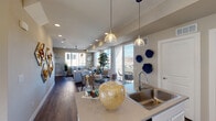 This well-appointed 3-story home offers a thoughtfully designed layout spread across multiple levels. The main living floor showcases an open-concept design where the kitchen flows seamlessly into the dining and living areas. The kitchen is outfitted with crisp white cabinetry, stainless steel appliances, a decorative mosaic tile backsplash, and a center island with a built-in sink and pendant lighting overhead. Rich hardwood flooring extends throughout the main level, complementing the warm neutral wall tones. The living room is generously proportioned, featuring recessed lighting, a ceiling fan, and an abundance of natural light streaming through large windows that frame open outdoor views. A dedicated office or flex room near the entry provides a quiet workspace with its own window and carpeted flooring. Bedrooms are comfortably sized with plush carpet, ample natural light from multiple windows, and a relaxed ambiance. Bathrooms are cleanly finished, including a full bath with a tub-shower combination and white cabinetry, as well as a powder room with a window and pedestal-style sink. A private outdoor balcony extends the living space further, offering open views of the surrounding landscape. Throughout the home, consistent neutral tones and quality finishes create a cohesive and inviting atmosphere.