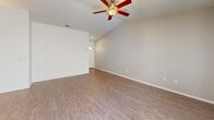 Located at 9800 Mesa Linda St in Hesperia, CA, this single-story, 2-bedroom, 2-bathroom home offers a well-designed layout with a clean, modern aesthetic throughout. The open-concept living and kitchen area serves as the heart of the home, featuring vaulted ceilings with a ceiling fan, wood-look laminate flooring, and natural light from windows fitted with blinds. The kitchen is equipped with rich dark cherry wood cabinetry, granite-style countertops, a central island, and a full suite of stainless steel appliances including a gas range, built-in microwave, dishwasher, and refrigerator. Both bedrooms are comfortably sized, each featuring ceiling fans, wood-look flooring, and windows that bring in natural light. The spacious primary bedroom includes a generous walk-in closet with wrap-around shelving and hanging rods. The bathrooms are finished with matching granite-style countertops, and one features a tub-shower combination with sliding glass doors. A welcoming entryway with a transom-lit front door connects the living areas. The attached two-car garage offers ample storage and parking space with an automatic opener.