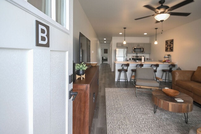 Inviting open-concept apartment with modern kitchen and cozy living area, perfect for relaxation and entertaining. - Orchard on Wallen
