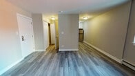 Located along West Foster Avenue in Chicago's vibrant 60640 zip code, this single-floor unit offers a clean, updated interior designed for comfortable everyday living. Throughout the space, durable hardwood-style plank flooring in a cool gray tone creates a cohesive and contemporary feel, complemented by neutral warm-beige walls and crisp white baseboards.

The open living area is well-proportioned, offering ample room for a variety of furniture arrangements. A window unit air conditioner and baseboard heating ensure year-round comfort, and a window provides natural light and views of the surrounding neighborhood.

The kitchen is a standout feature, finished with white shaker-style cabinetry, dark countertops, a stainless steel undermount sink, and a classic white subway tile backsplash. Stainless steel appliances — including a gas range, over-the-range microwave, and refrigerator — complete the modern culinary setup.

A hallway with a louvered closet door leads to the private areas of the unit, including a bedroom with its own closet access. The bathroom includes a grab bar and coordinating brushed nickel fixtures, reflecting thoughtful, accessible design details throughout. The overall ambiance is bright, neutral, and move-in ready.