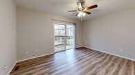 Located at 2752 S Meadowbrook Ave in Springfield, MO, this well-appointed one-bedroom, one-bathroom unit offers a practical and comfortable single-floor layout. The living room is bright and inviting, featuring durable wood-look plank flooring, a ceiling fan with light fixture, and sliding glass doors that open to a private balcony overlooking the outdoor common area — allowing natural light to fill the space throughout the day. The entryway area continues the wood-look flooring and provides a clean transition into the main living space. The bedroom is carpeted for comfort, fitted with its own ceiling fan, and benefits from a natural light source through a window. A standout feature of the bedroom is its impressive storage capacity, with two side-by-side closets offering generous wardrobe space. The bathroom is finished with a dark wood vanity cabinet topped with a marble-look countertop and an undermount sink, complemented by brushed nickel fixtures and a well-lit mirror. The kitchen includes dark cabinetry consistent with the bathroom's design aesthetic. Additional highlights include dedicated laundry facilities and multiple closets throughout. The unit maintains a neutral, light color palette that creates a clean and cohesive atmosphere.