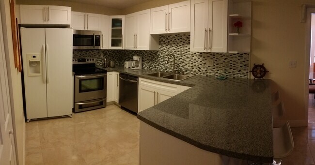 Kitchen with granite counter top and SS dishwasher, range and microwave. - 23 Lycaloma Ave
