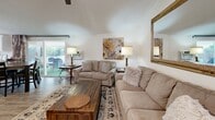 Located at 6679 La Jolla Dr in Riverside, California, this single-story, 3-bedroom, 2-bathroom home offers a well-designed layout that makes efficient use of its space. The home is finished with light wood-style flooring throughout the main living areas, lending a clean, cohesive look across rooms.

The living room is a welcoming centerpiece, featuring vaulted ceilings, a ceiling fan, a wall-mounted mini-split unit for climate control, and a large decorative mirror that enhances the sense of space. A sliding glass door allows natural light to flow in while providing views of the outdoor patio area.

The kitchen has been thoughtfully updated with crisp white shaker cabinetry, granite-style countertops, stainless steel appliances including a French door refrigerator, dishwasher, and over-range microwave, plus a window above the sink that brings in additional natural light.

The primary bedroom is generously sized, featuring plush carpeting, multiple windows with views of the greenery outside, and ample room for large furnishings. The additional bedrooms are comfortable and well-lit with good closet access. The bathrooms feature marble-style tiled tub surrounds for a clean, updated aesthetic.

Outside, the property is shaded by mature trees, with a concrete patio area, artificial turf, and a spacious yard — ideal for outdoor relaxation.