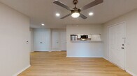 This single-story unit in Robinsonville, Mississippi offers a well-designed, efficiently utilized floor plan that maximizes its compact footprint. The open-concept living area is finished with light wood laminate flooring that runs consistently throughout the space, creating a cohesive and airy feel. Recessed lighting and a ceiling fan with an integrated light fixture illuminate the main living area, which flows seamlessly toward the front entry door.

The kitchen is accessible via a pass-through opening from the living area, featuring white shaker-style cabinetry, marble-look countertops, a white subway tile backsplash, and stainless steel Whirlpool appliances including an electric range and over-the-range microwave. The layout provides functional counter and storage space.

The bedroom is a well-proportioned, quiet space with a ceiling fan, a window fitted with blinds for natural light control, and direct access to a dedicated walk-in closet outfitted with built-in shelving and hanging rods.

The full bathroom includes a single-sink vanity with a marble-look countertop, white cabinetry, a lighted mirror, overhead storage cabinets, and a tub/shower combination. The unit presents a clean, move-in-ready condition throughout.