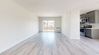 Located at 980 S Menlo Ave in Los Angeles, this thoughtfully updated 2-bedroom, 2-bathroom unit offers a clean, modern aesthetic throughout its single-floor layout. Light wood-style vinyl flooring flows seamlessly through every room, creating a cohesive and contemporary feel.

The open living area is bright and airy, anchored by a sliding glass door that invites natural light and provides views of the surrounding neighborhood. The galley-style kitchen is well-appointed with gray shaker cabinetry, white quartz countertops, stainless steel appliances including a refrigerator, electric range, and dishwasher, plus a window that adds additional natural light.

Both bedrooms are comfortably sized, each featuring ceiling fans and large windows that allow ample sunlight. The spacious primary bedroom includes access to a dedicated closet. The second bedroom mirrors the bright, airy feel with a wide window framing neighborhood views.

The two bathrooms are finished with the same modern sensibility — one features a dual-sink vanity with gray cabinetry and white countertops, while the second offers a clean, functional layout with dark cabinetry and wood-tone flooring. Clean white walls throughout the unit enhance the light, open ambiance of this well-designed Los Angeles residence.