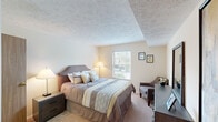 This well-appointed 2-bedroom, 1-bathroom residence at 100 Hunt Club Dr in Copley, Ohio offers a practical and comfortable single-floor layout. The living room provides a welcoming gathering space with soft carpeting, textured ceilings, and ample room for seating arrangements. Adjacent to the living area, the dining room features a ceiling fan with light fixture, creating a comfortable space for meals. A hallway connects the main living areas to the private quarters, lined with carpeting throughout.

The galley-style kitchen is efficiently designed with warm oak cabinetry, granite-look countertops, hardwood-style flooring, and white appliances including a refrigerator, electric range, microwave, and dishwasher. A dedicated laundry room with shelving and utility hookups adds everyday convenience.

The generously sized primary bedroom offers a walk-in closet with built-in shelving and hanging rods, a window with natural light, and comfortable proportions. The second bedroom is similarly well-sized with its own closet. The full bathroom includes a granite-topped vanity, tiled flooring, and a tub-shower combination. Together, these spaces create a functional, move-in-ready home in Copley, Ohio.