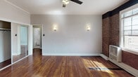 Located at 525 S Gramercy Place in the heart of Los Angeles, this single-floor unit blends classic character with modern updates. Rich, polished hardwood floors run throughout the space, reflecting light and adding warmth to every room.

The living area is a standout, showcasing a striking exposed brick accent wall that adds industrial charm and texture. A ceiling fan keeps the space comfortable, while a large multi-pane window invites natural light and frames views of the surrounding greenery. The open layout flows naturally into adjacent spaces, creating a connected and functional floor plan.

The bedroom is generously sized and features the same gleaming hardwood floors, a ceiling fan, soft wall sconces, and ample closet storage, including a walk-in closet. Its neutral tones and clean lines offer a calm, restful atmosphere.

The kitchen is well-equipped with white shaker cabinetry, dark countertops, a stainless steel gas range, refrigerator, and double-basin sink — providing both style and practicality for everyday cooking.

The bathroom is bright and neatly finished with classic white subway tile lining the shower/tub surround, a pedestal sink, and a window that brings in natural light. The overall aesthetic is clean and timeless.

This thoughtfully designed space balances vintage architectural details with modern conveniences in a prime Los Angeles location.
