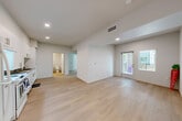 Located at 65 Shiloh Rd in Windsor, California, this single-floor, three-bedroom, two-bathroom home offers a clean, modern design with a bright and airy feel throughout. Light-toned wood flooring flows seamlessly across all living areas, complementing the crisp white walls and recessed lighting that illuminate each room.

The open living area is well-proportioned, featuring a glass door that brings in natural light and provides access to the exterior. The kitchen is a standout feature, equipped with an abundance of tall white cabinetry offering generous storage, granite countertops, a stainless steel sink, and white appliances including a range, dishwasher, and refrigerator — all set beneath recessed lighting.

Each of the three bedrooms is finished with the same warm wood flooring and neutral tones, with windows that allow natural light to filter in. The primary bedroom provides a comfortable, functional space, while the two secondary bedrooms are well-suited for guests, a home office, or other uses.

The two bathrooms are cleanly appointed with white vanities, tub-shower combinations, and light wood-style flooring, maintaining the home's consistent modern aesthetic. A hallway connects the bedrooms and bathrooms, contributing to an efficient and practical layout throughout this well-designed Windsor residence.