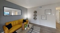 Located in Dallas, TX, this one-bedroom, one-bathroom residence offers a thoughtfully designed single-floor layout that maximizes every square foot. The living room serves as the heart of the home, featuring wood-style flooring, a textured ceiling, and a bold accent wall. A sliding glass door floods the space with natural light and opens directly onto a private balcony, providing a pleasant outdoor retreat with tree-lined views. The kitchen is well-equipped with dark shaker-style cabinetry, granite-look countertops, a classic white subway tile backsplash, and stainless steel appliances, creating a functional and stylish cooking space. The bedroom is carpeted for comfort and includes a ceiling fan, two accent walls, and direct access to a dedicated walk-in closet, offering generous storage. The full bathroom features a combined tub and shower with white tile surround, a dark-framed vanity mirror, and wood-style flooring that ties the space together. A hallway connects the rooms efficiently, and an entry area includes built-in shelving for added convenience. Throughout the residence, a neutral color palette with modern accents creates a cohesive and inviting atmosphere.