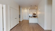 This thoughtfully designed single-floor residence offers a clean, contemporary aesthetic throughout. The open-concept kitchen serves as a central highlight, featuring stainless steel appliances including a french door refrigerator, electric range, and built-in microwave. Light wood-grain cabinetry pairs with gray quartz-style countertops, while a peninsula with an undermount sink and pendant lighting adds both functionality and style. Wood-style plank flooring flows through the main living and kitchen areas, creating a cohesive and easy-to-maintain surface.

The bedrooms offer a softer feel with plush neutral carpet and natural light from window with blinds. Generous closet space is provided throughout, including a spacious walk-in closet with built-in shelving and hanging rods. The bathrooms are finished with modern light wood vanities, gray countertops, undermount sinks, and wood-style vinyl flooring. One bathroom includes a soaking tub and shower combination, while the primary bath features an elongated vanity and direct access to the walk-in closet.

The overall ambiance is bright and neutral, with crisp white walls, recessed lighting, and clean lines that create a calm, move-in-ready environment suited for a variety of living styles.
