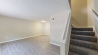 Located in Marietta, GA, this two-bedroom, two-bathroom two-story home offers a well-organized layout spread across two floors. The main level features a welcoming living area with light wood-style laminate flooring, neutral warm-toned walls, and clean white trim and baseboards throughout. A staircase with carpeted treads and a white banister connects the two levels, adding a classic touch to the design. The kitchen is equipped with rich cherry-toned cabinetry, granite-style countertops, black appliances including a gas range and refrigerator, and a dishwasher, creating a functional and stylish cooking space. A half bathroom on the main level features a vanity with granite-style countertops and warm wood cabinetry. Upstairs, the spacious primary bedroom is carpeted and includes a large double-door closet and a window allowing natural light to filter in. The second bedroom is also carpeted and offers a bright, open feel. The full upstairs bathroom features a tiled tub-shower combination with brushed nickel fixtures and matching vanity finishes. A closet provides additional storage on the upper level. Neutral tones and consistent finishes throughout give the home a cohesive and well-maintained ambiance.